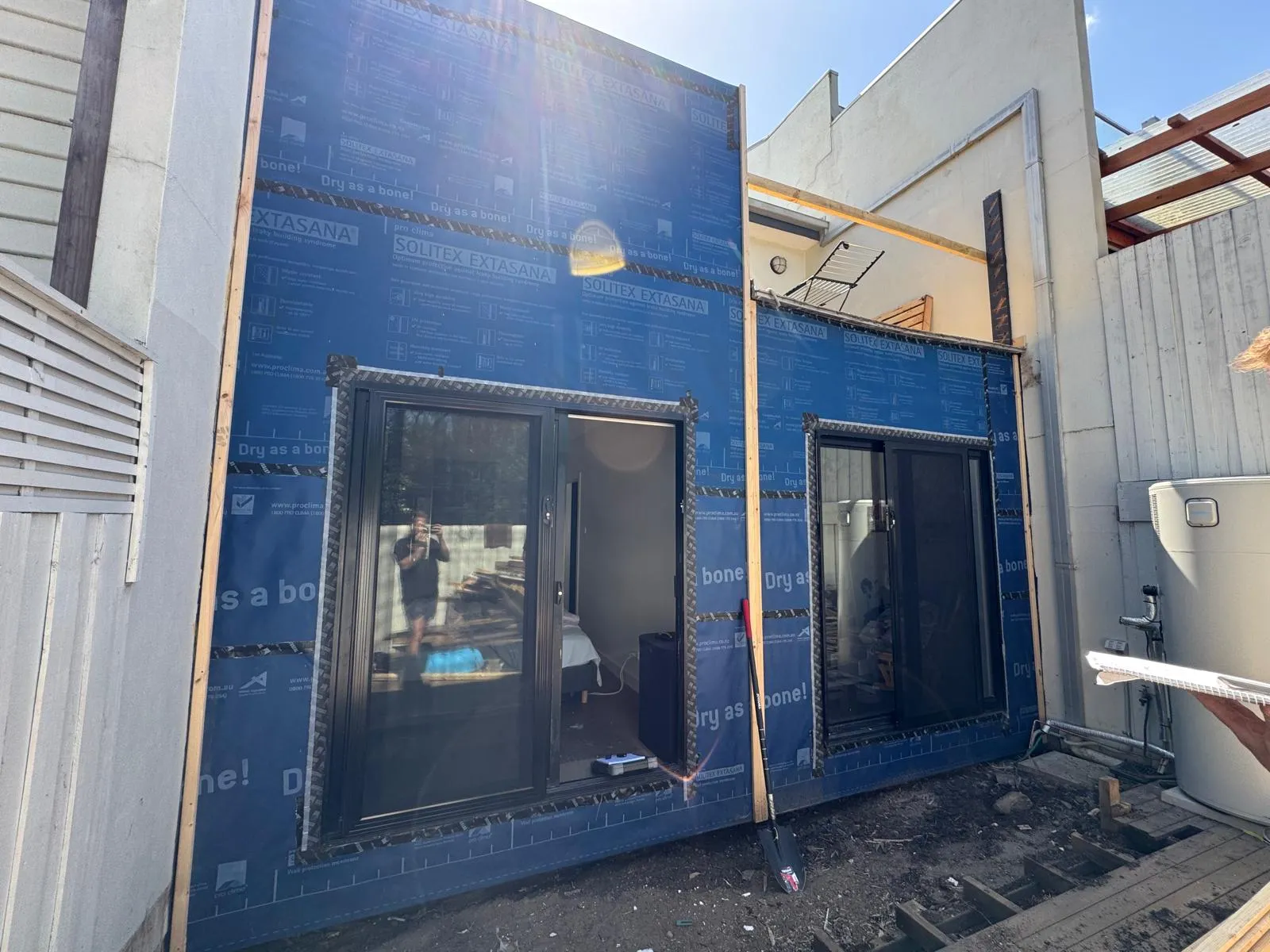 Exterior wall wrapped in a weatherproof membrane with new window frames